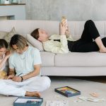 Father and daughter bonding in cozy living room with books and games, creating joyful family moments.